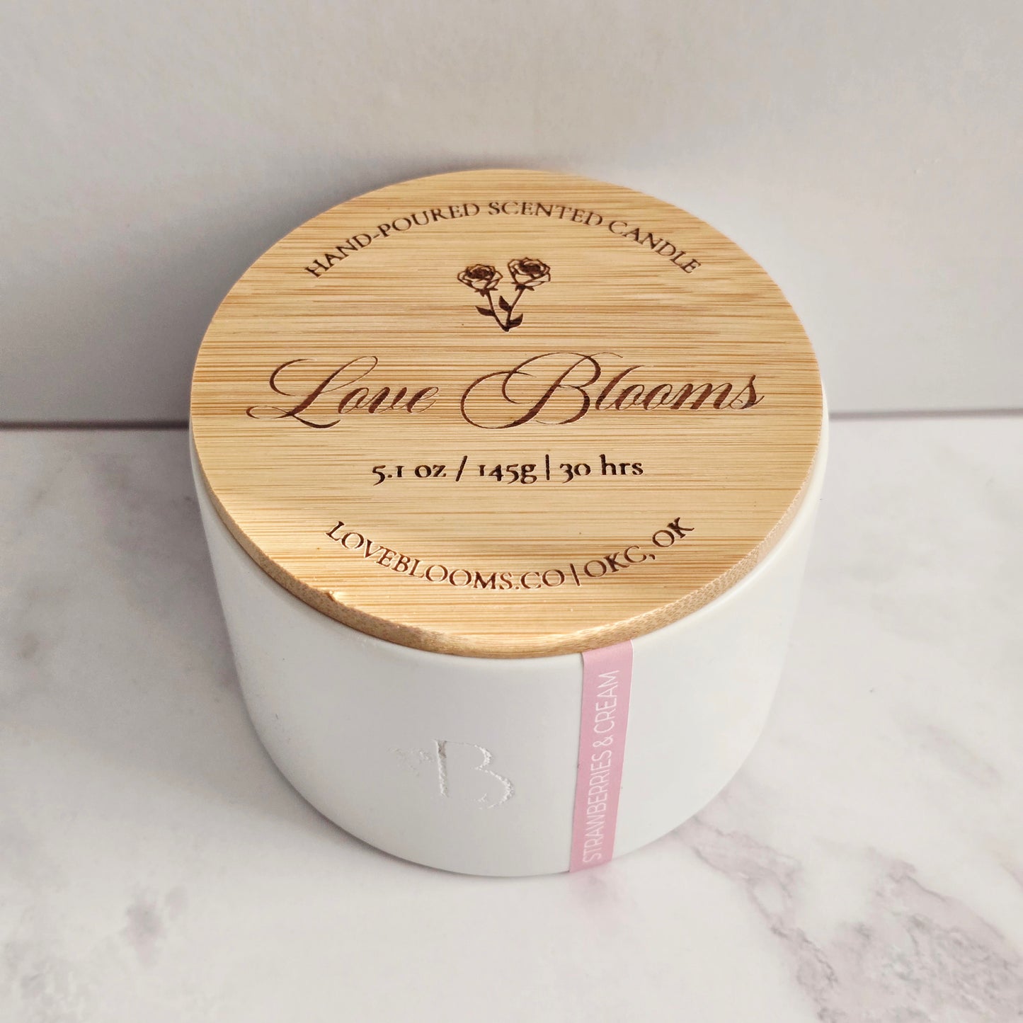 White candle with a wooden lid on a marble surface