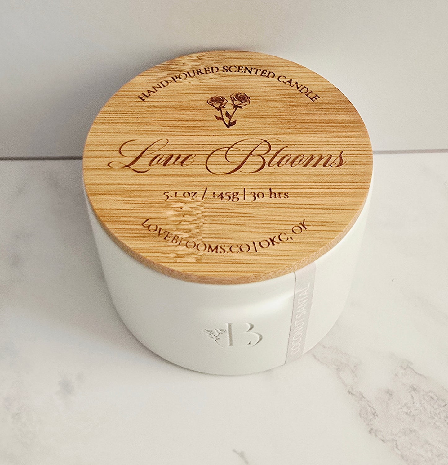 White candle with a wooden lid on a marble surface