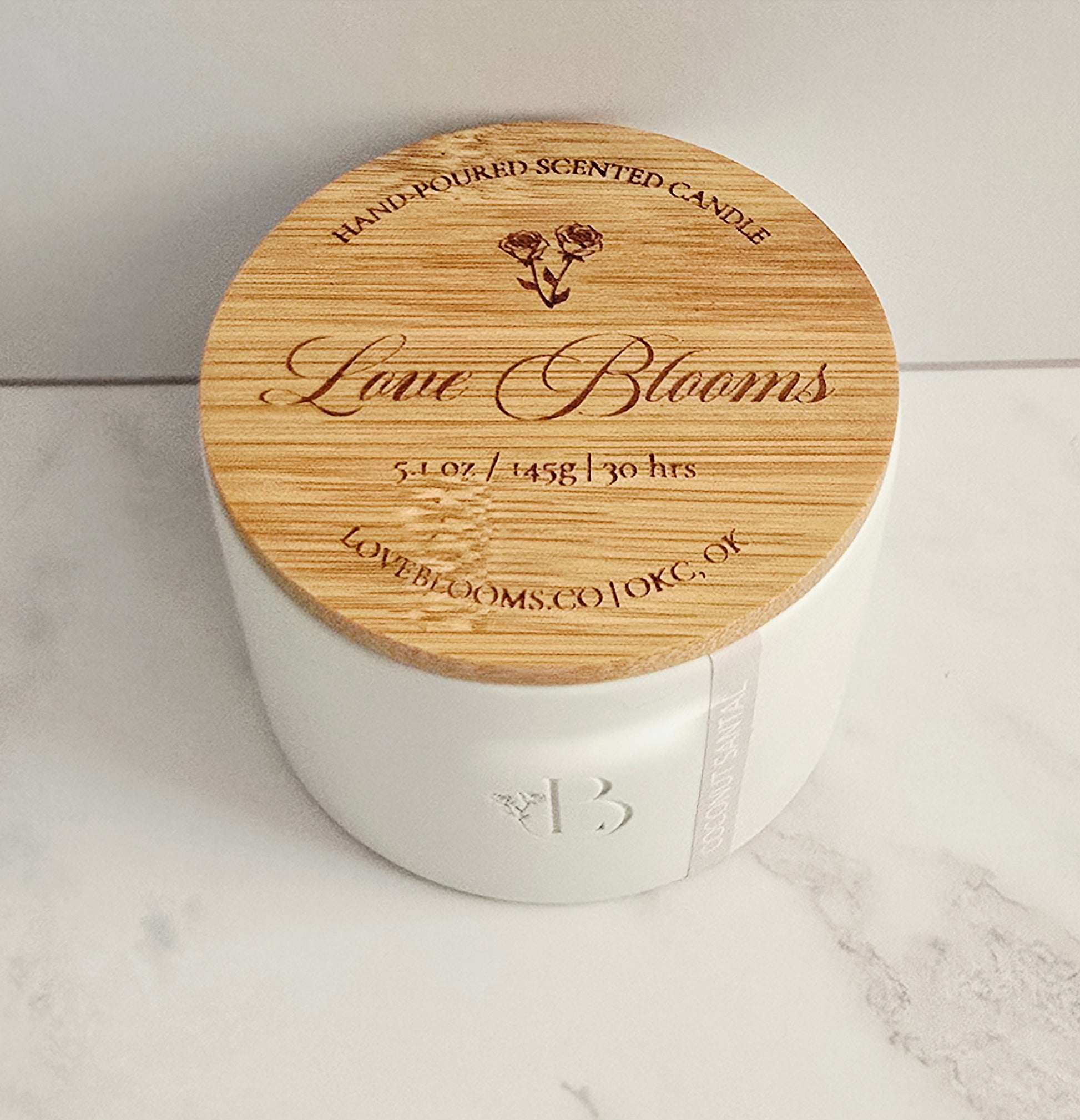 White candle with a wooden lid on a marble surface