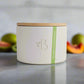 White candle jar with a wooden lid and 'B' logo on a light gray background