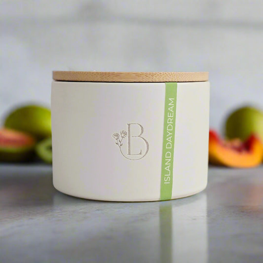 White candle jar with a wooden lid and 'B' logo on a light gray background