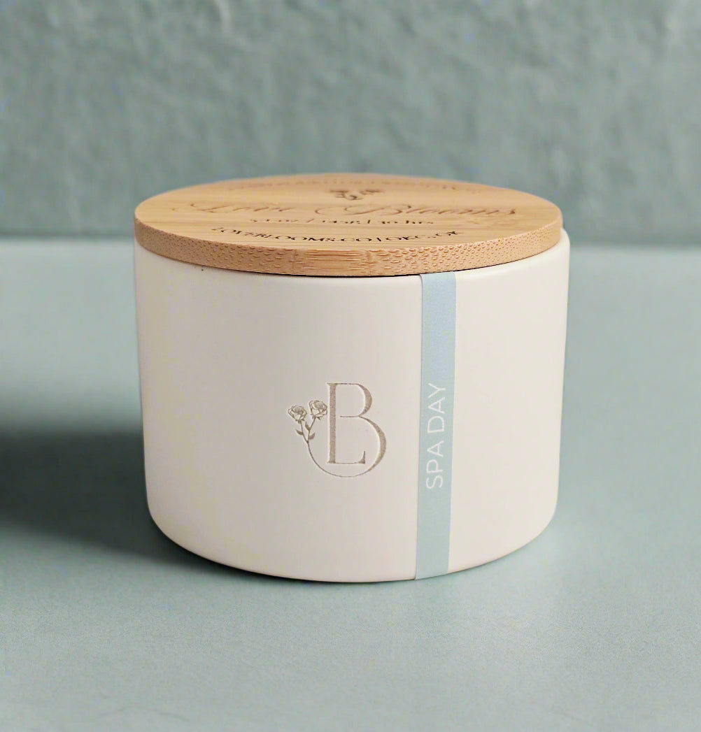White ceramic jar with wooden lid on a light surface