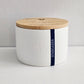 White container with a wooden lid on a light gray background