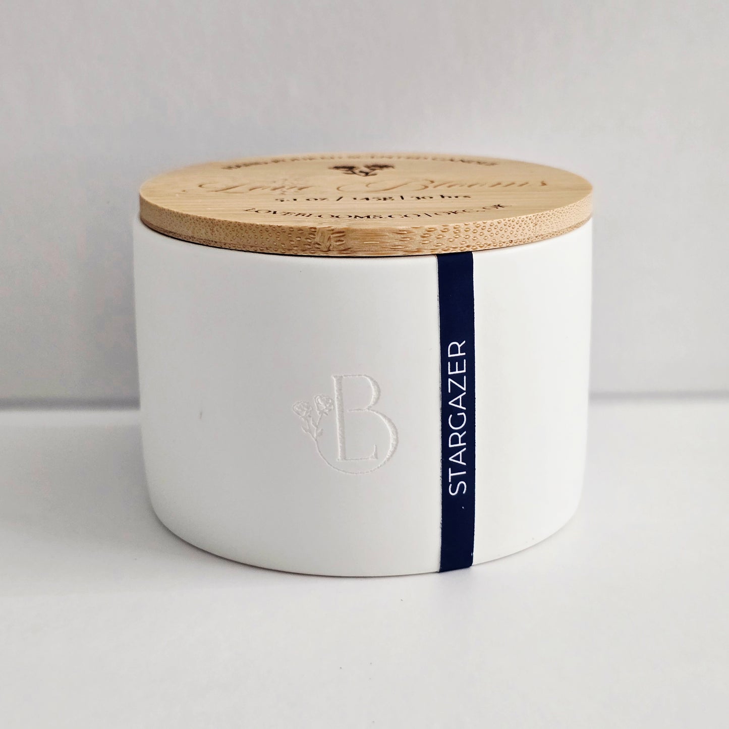 White container with a wooden lid on a light gray background