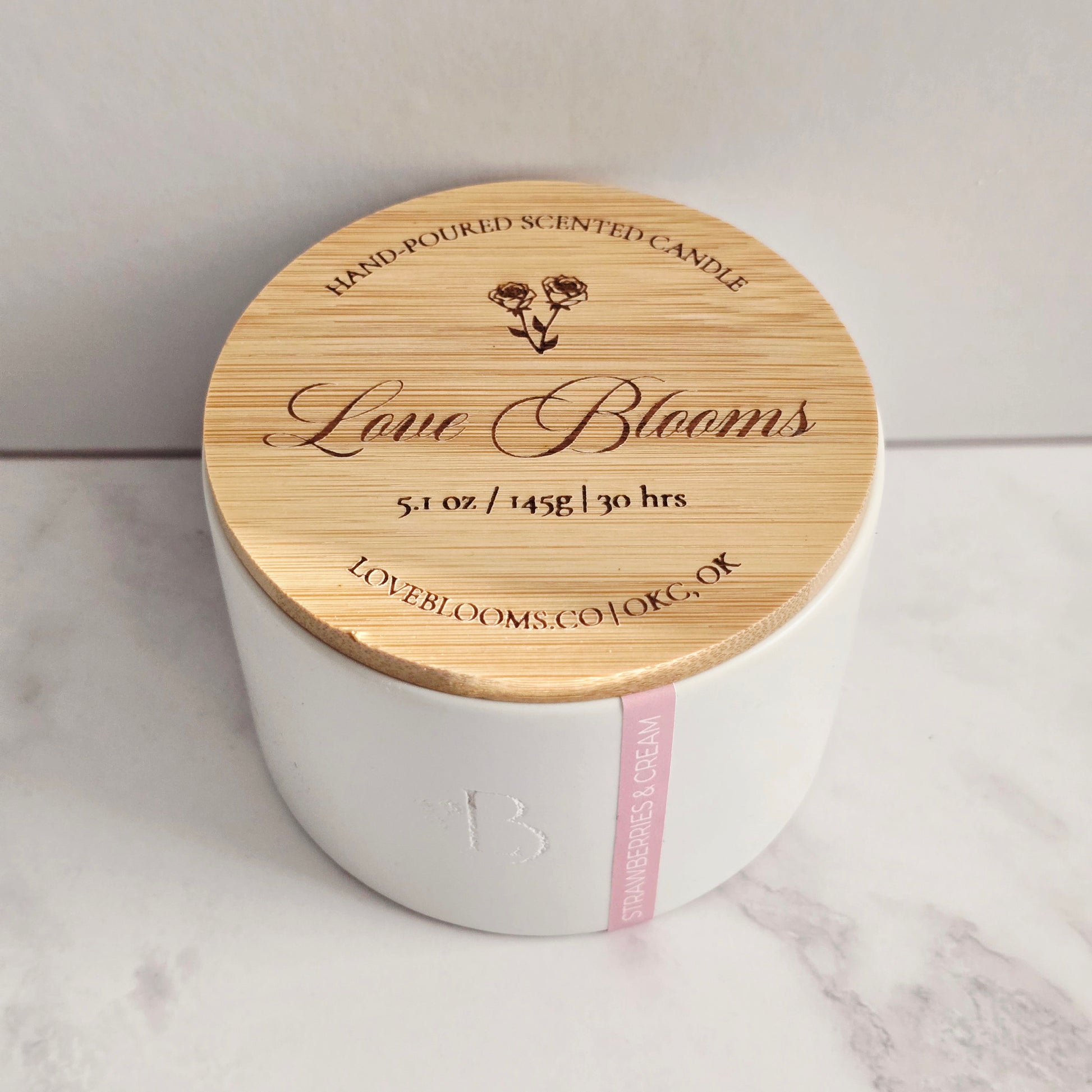 White candle with a wooden lid on a marble surface