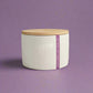 White candle jar with wooden lid and 'Sugarplum Waltz' label on a light background