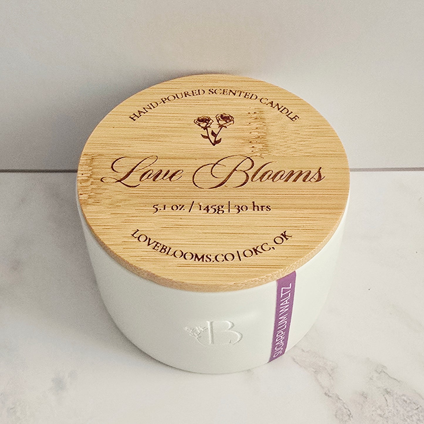 White candle with a wooden lid on a marble surface