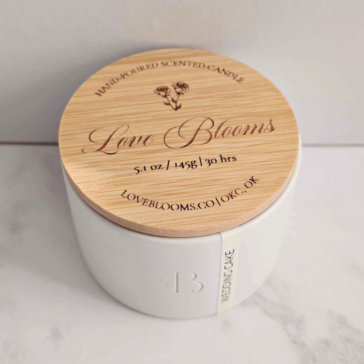 White candle with a wooden lid on a light background