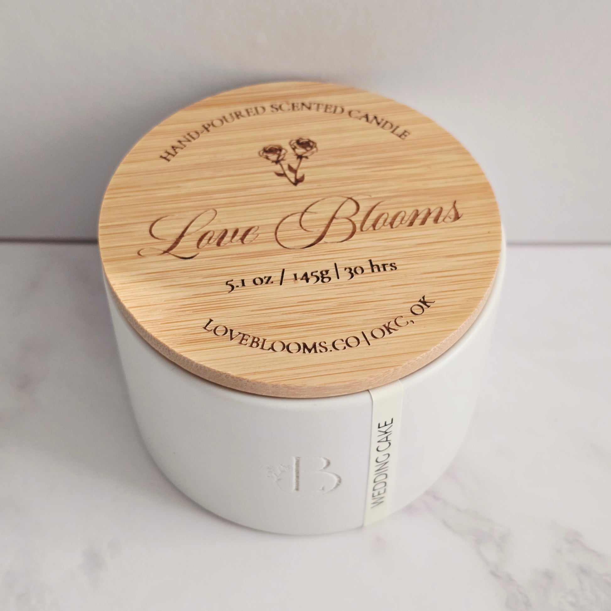 White candle with a wooden lid on a light background