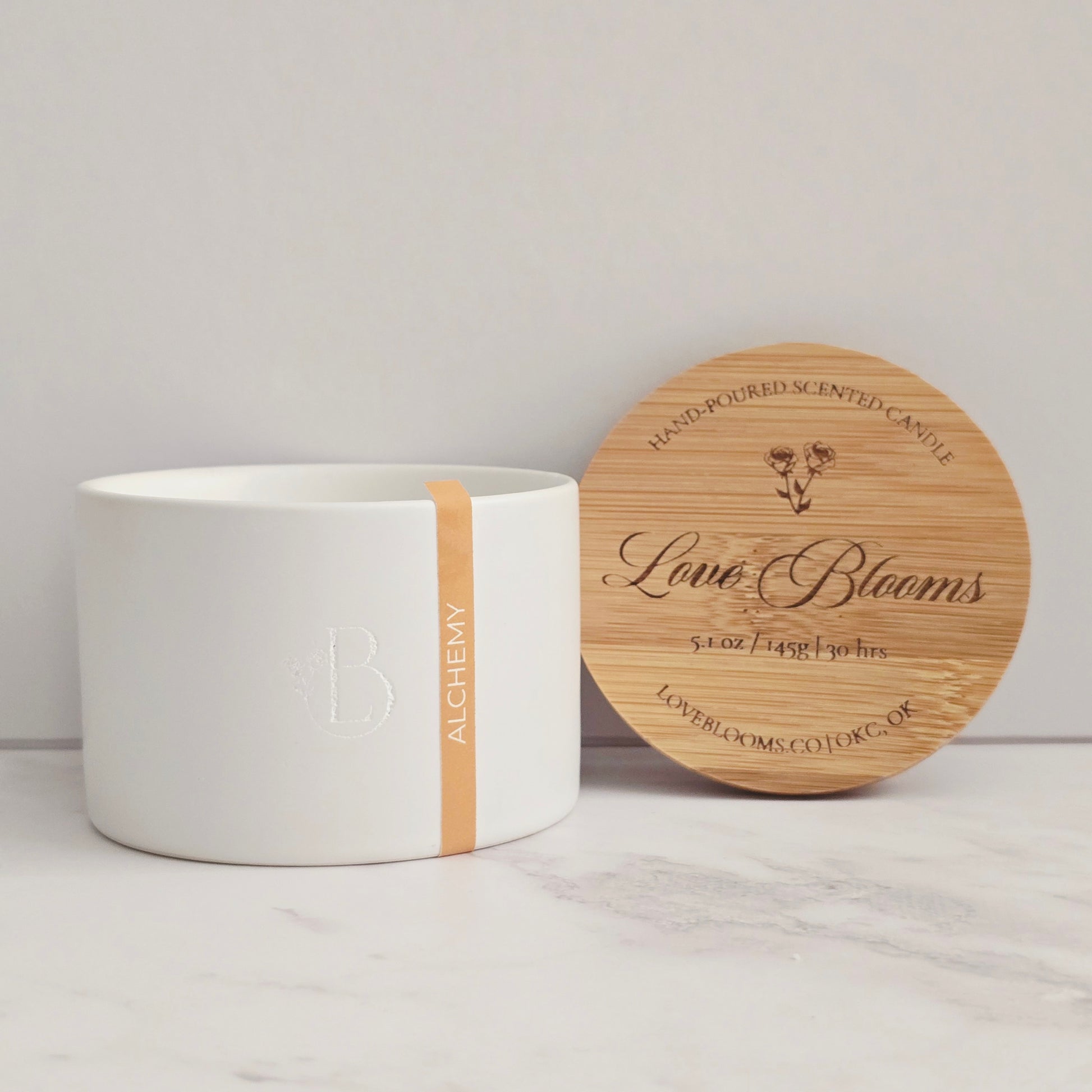 White candle with wooden lid on a light gray background