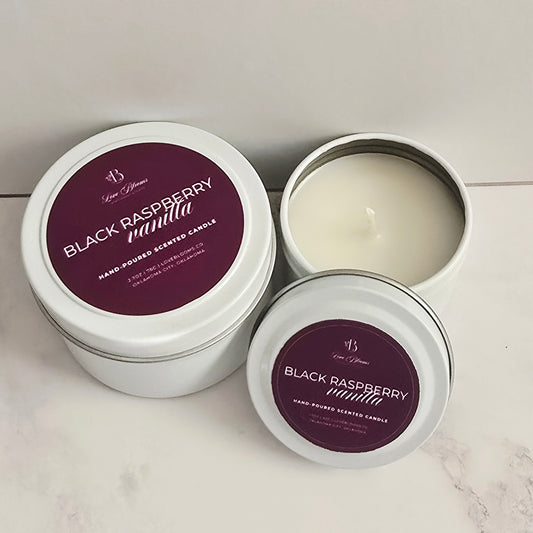 Two tins of 'Black Raspberry Vanilla' candles on a light surface