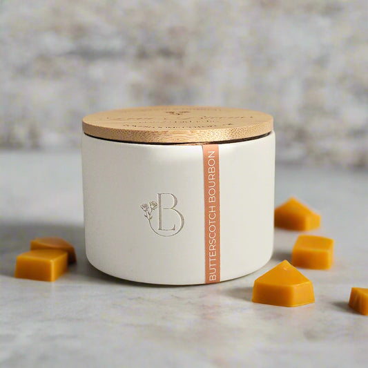 White ceramic jar with wooden lid on a marble surface