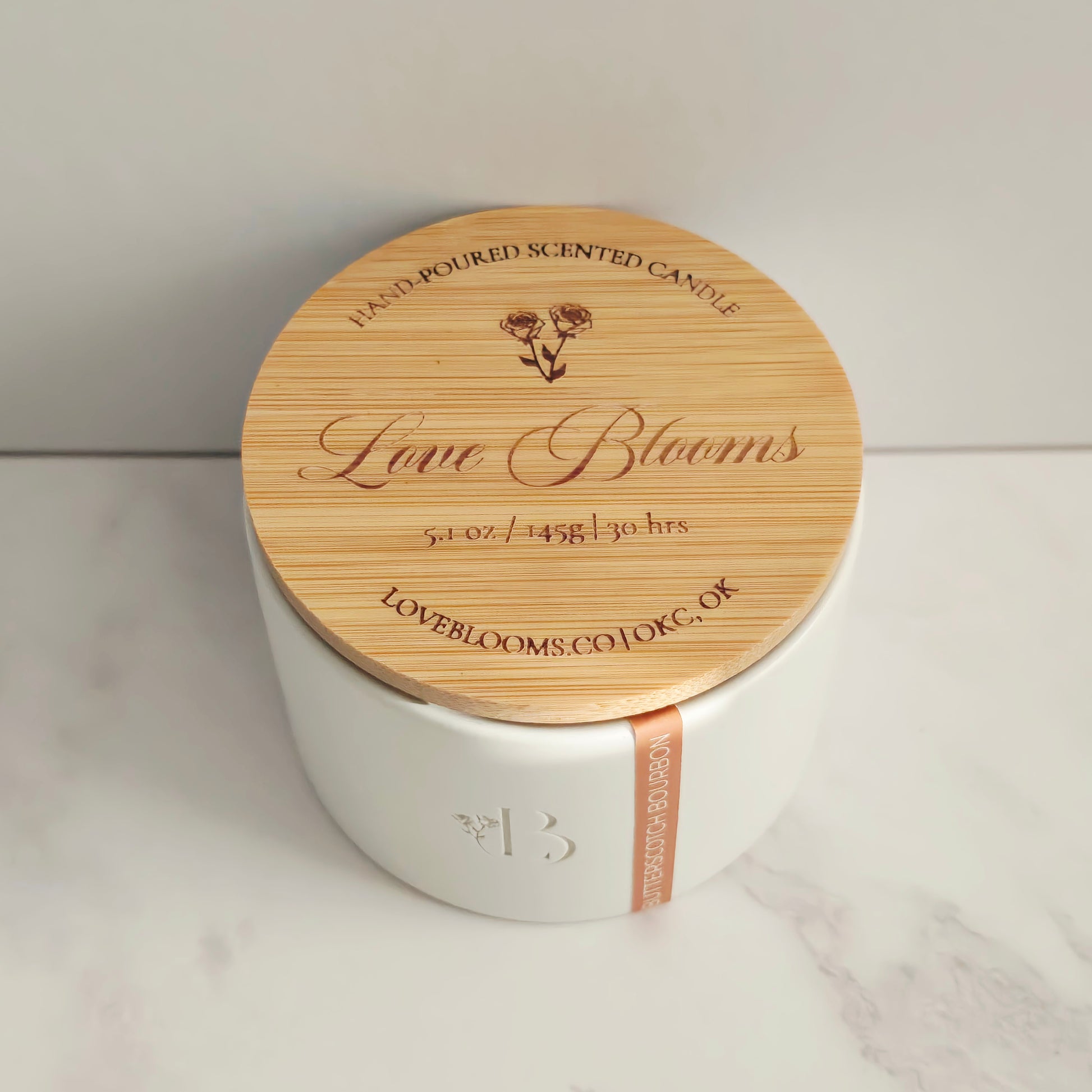 Candle with wooden lid on a white surface