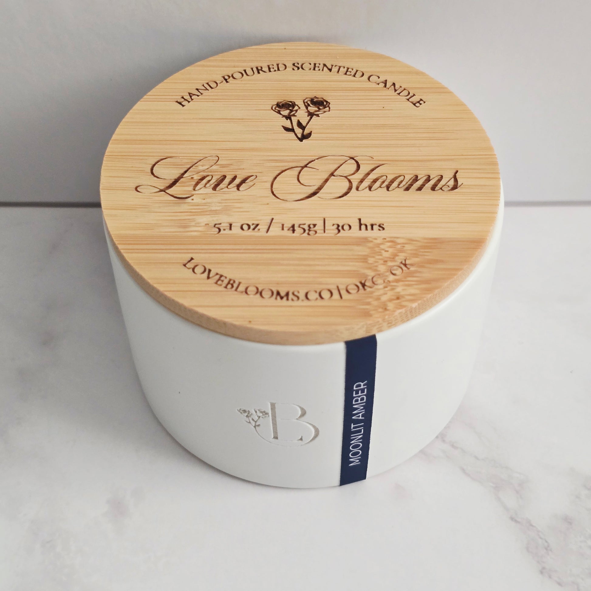 White candle with a wooden lid on a marble surface