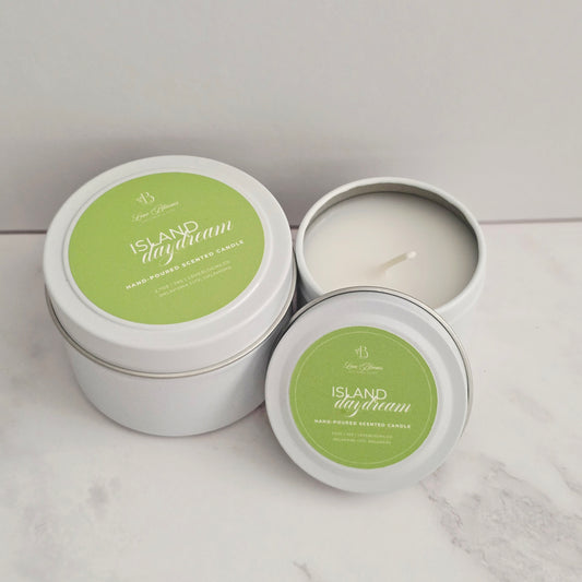 Two candles in metal tins with 'Island Daydream' label on a light background